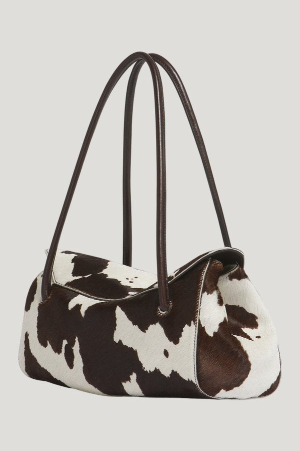 White and brown cow-print ponyhair E/W shoulder bag — model side